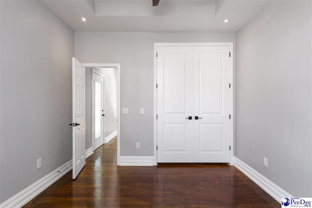 unfurnished bedroom with dark hardwood / wood-style flooring and a closet