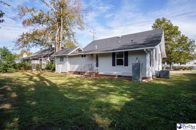 back of property featuring central AC and a lawn