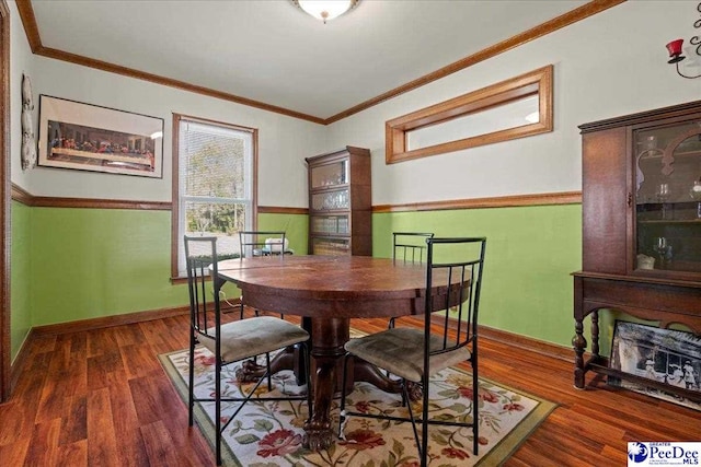 dining area with crown molding, baseboards, and wood finished floors