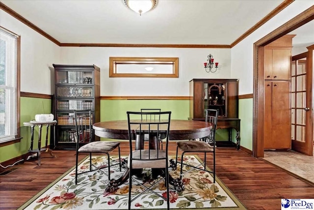 dining space with ornamental molding, wood finished floors, and baseboards