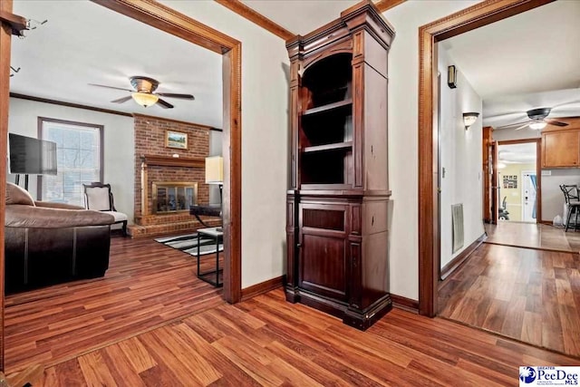 hallway with baseboards, wood finished floors, and crown molding