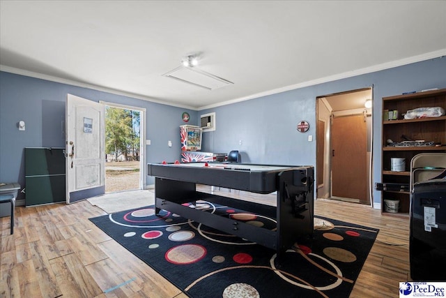 game room featuring crown molding, baseboards, and wood finished floors