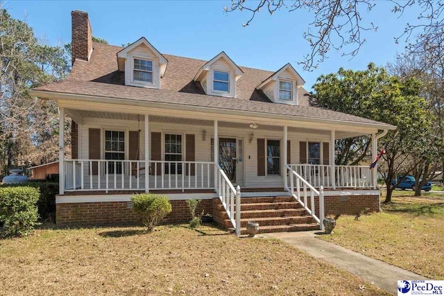 view of front of house with roof with shingles, a porch, and a front lawn