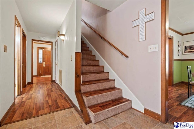 staircase featuring baseboards and wood finished floors