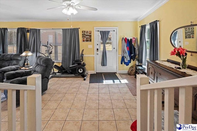 foyer entrance with ceiling fan, baseboards, crown molding, and light tile patterned flooring