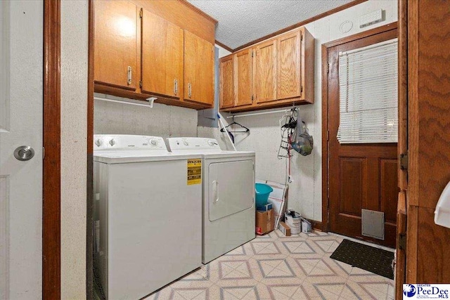 washroom featuring a textured ceiling, light floors, washing machine and clothes dryer, and cabinet space