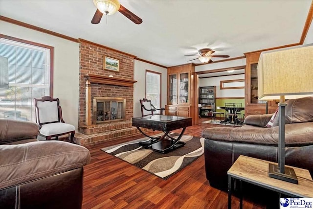 living room featuring ornamental molding, a brick fireplace, ceiling fan, and wood finished floors