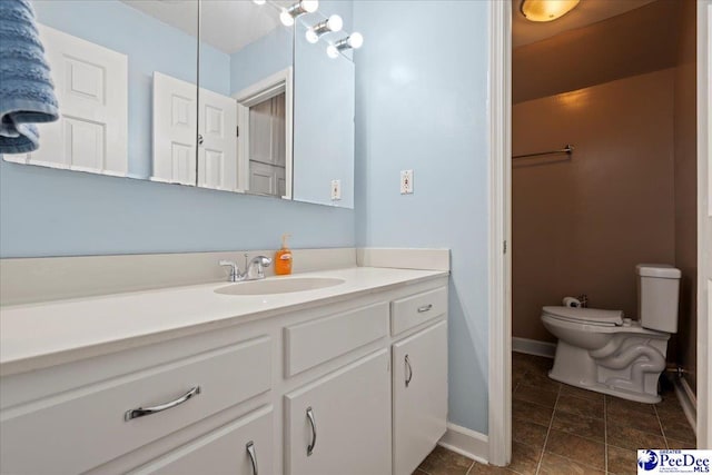 bathroom featuring vanity, toilet, and baseboards