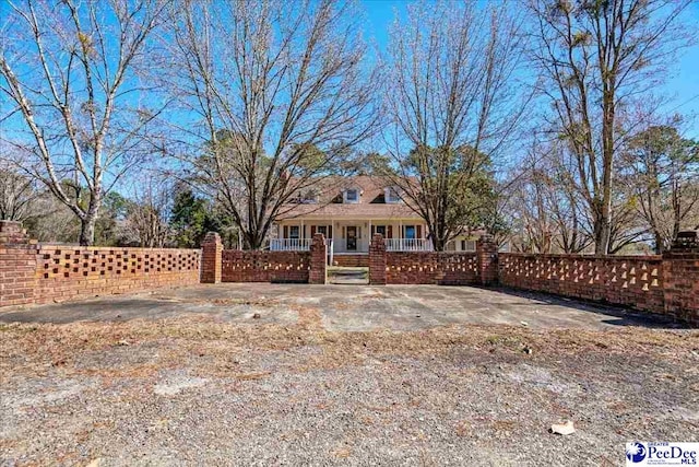 view of front of home with covered porch and a fenced front yard