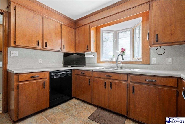 kitchen with a sink, brown cabinetry, light countertops, and dishwasher