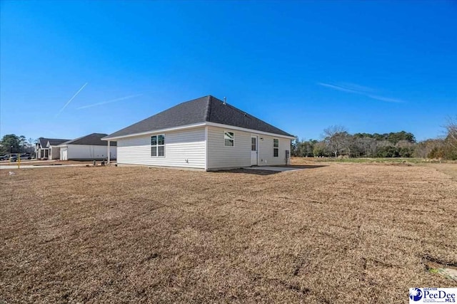 view of side of property featuring a patio and a yard