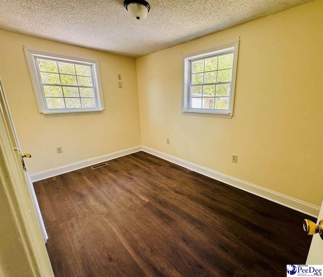 spare room with visible vents, plenty of natural light, and a textured ceiling