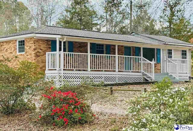 view of front of house with a porch and brick siding