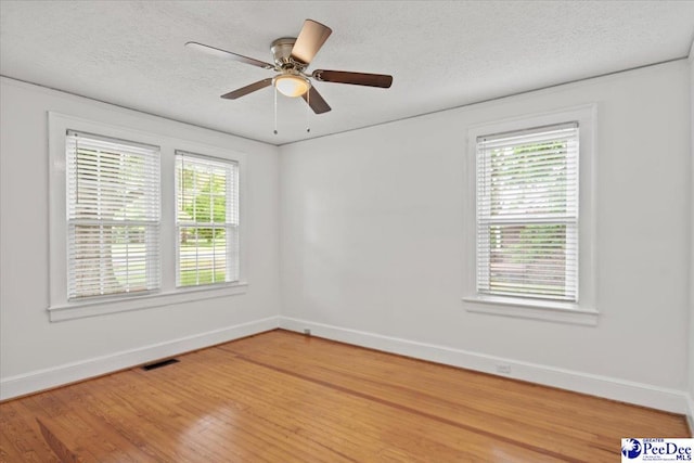 312 Greene St, Cheraw, SC 29520 - empty room with healthy amount of natural light, baseboards, light wood finished floors, a textured ceiling, and ceiling fan