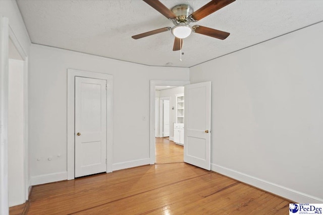 312 Greene St, Cheraw, SC 29520 - unfurnished bedroom featuring light wood-style floors, baseboards, a textured ceiling, and a ceiling fan