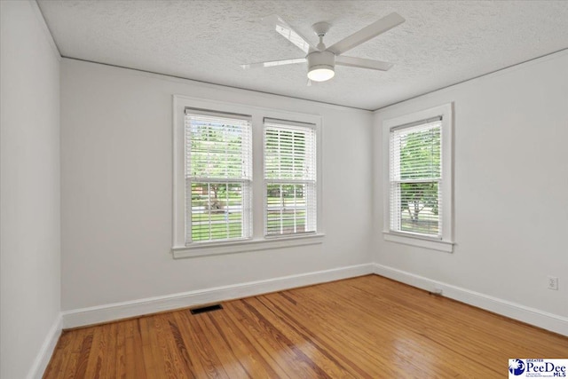312 Greene St, Cheraw, SC 29520 - empty room featuring a textured ceiling, baseboards, light wood-style floors, and a ceiling fan