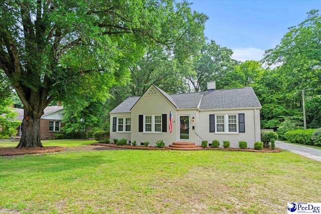 312 Greene St, Cheraw, SC 29520 - ranch-style house with a front yard, a chimney, stucco siding, and a shingled roof