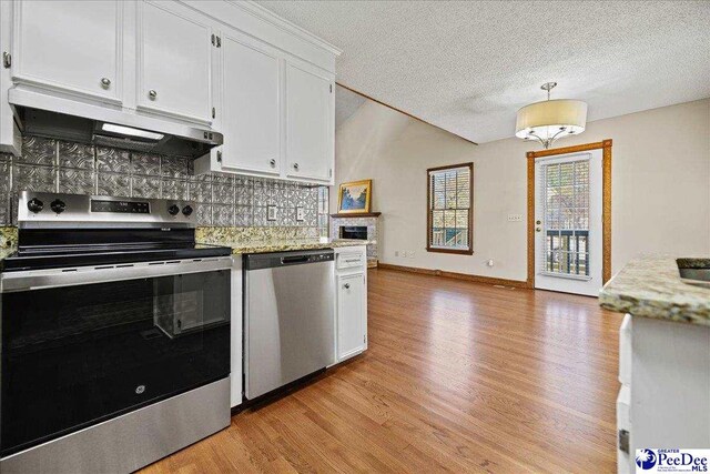 kitchen featuring backsplash, white cabinetry, light wood-type flooring, under cabinet range hood, and stainless steel appliances