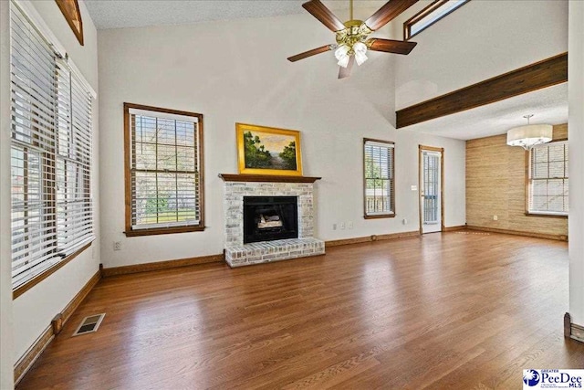 unfurnished living room with wood finished floors, a wealth of natural light, and visible vents