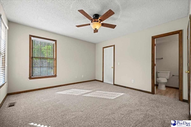 unfurnished bedroom featuring baseboards, visible vents, carpet flooring, and a textured ceiling