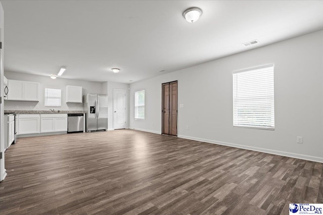 3229 Winding Way Dr, Florence, SC 29506 - unfurnished living room featuring dark wood finished floors, baseboards, and a sink