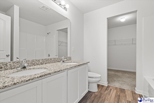 3229 Winding Way Dr, Florence, SC 29506 - full bath featuring wood finished floors, toilet, a shower, a walk in closet, and double vanity