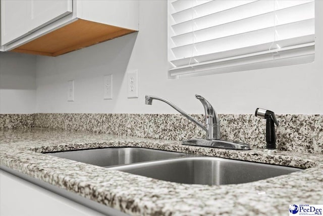 3229 Winding Way Dr, Florence, SC 29506 - kitchen view of a sink, white cabinets, and light stone counters
