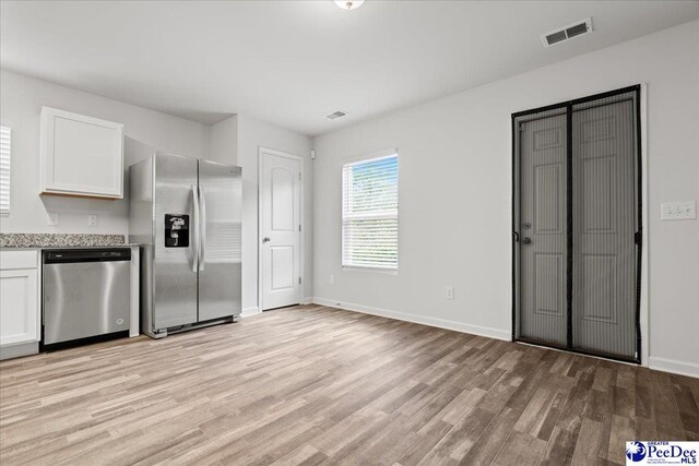 3229 Winding Way Dr, Florence, SC 29506 - kitchen with appliances with stainless steel finishes, light wood-type flooring, white cabinets, and baseboards