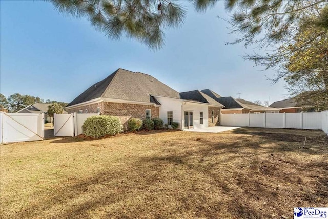 back of property featuring a patio and a yard