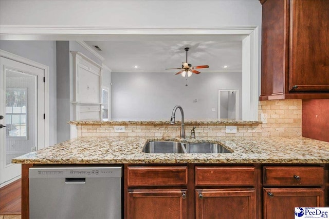 kitchen featuring light stone counters, dishwasher, sink, and backsplash