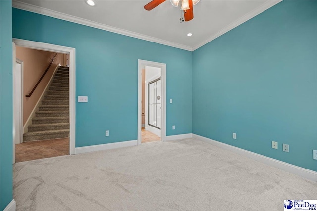 carpeted empty room featuring crown molding and ceiling fan