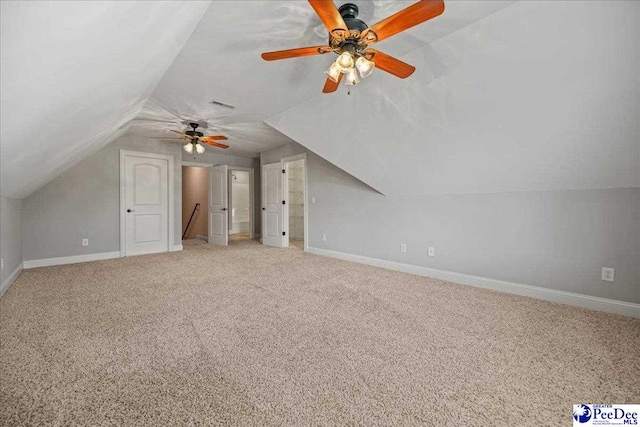 bonus room with vaulted ceiling and carpet floors