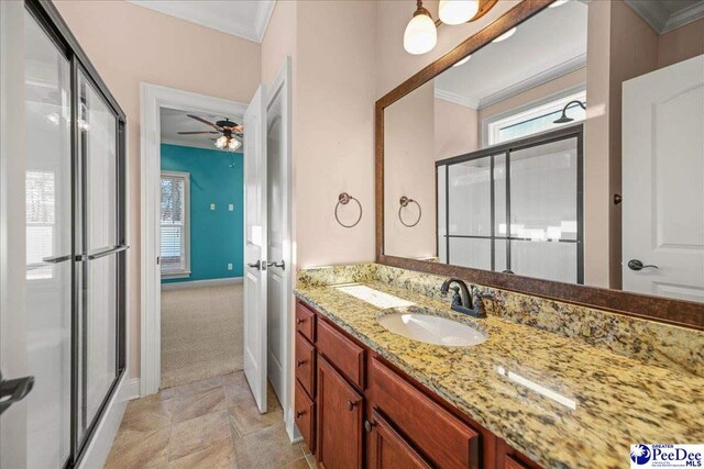 bathroom featuring ornamental molding, a shower with door, and vanity