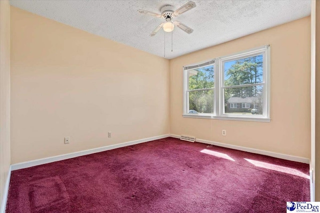 unfurnished room with dark carpet, a textured ceiling, visible vents, baseboards, and ceiling fan