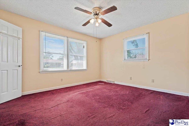 carpeted spare room with a ceiling fan, baseboards, visible vents, and a textured ceiling