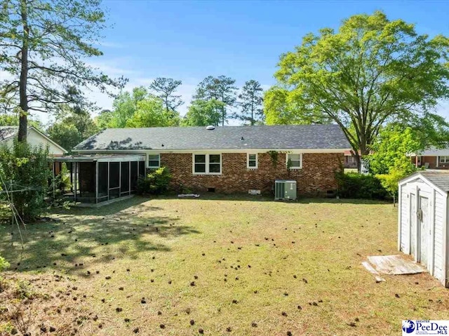 back of property featuring a storage unit, a sunroom, crawl space, central air condition unit, and a yard