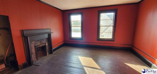 unfurnished living room featuring ornamental molding and dark wood-type flooring