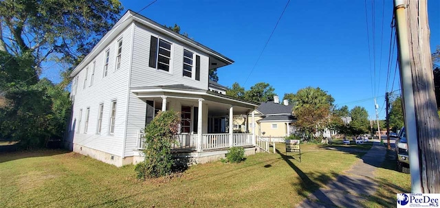 view of front facade with a front yard and covered porch