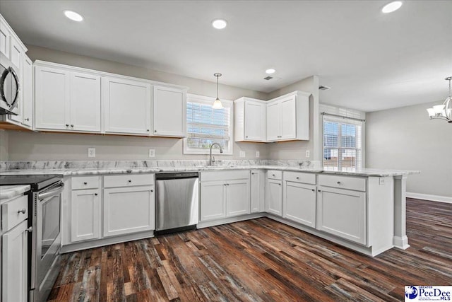 kitchen featuring stainless steel appliances, a sink, decorative light fixtures, and white cabinets