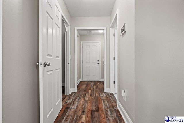 corridor with baseboards and dark wood-style flooring