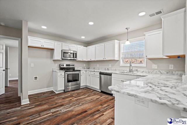 kitchen featuring stainless steel appliances, visible vents, hanging light fixtures, white cabinets, and a sink