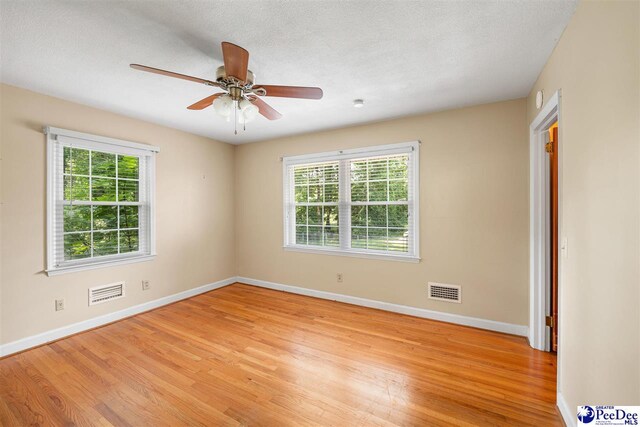 3116 Kenfield Ln, Florence, SC 29505 - unfurnished room featuring light wood-style floors, baseboards, ceiling fan, and a textured ceiling