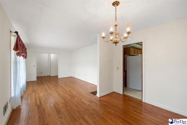 3116 Kenfield Ln, Florence, SC 29505 - empty room with a chandelier, light wood-type flooring, and baseboards