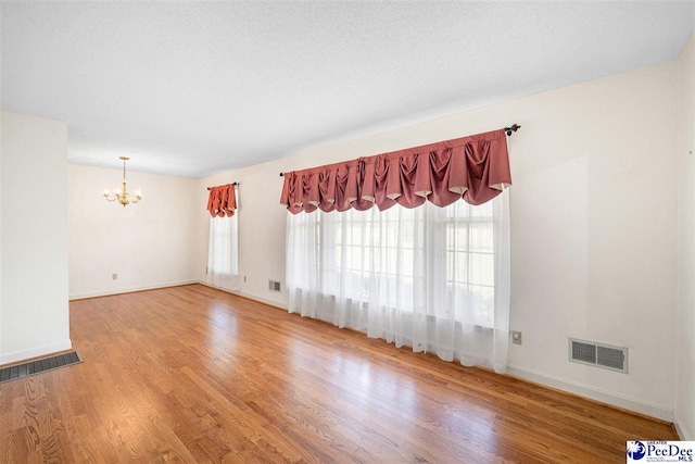 3116 Kenfield Ln, Florence, SC 29505 - unfurnished room with a chandelier, wood finished floors, and baseboards