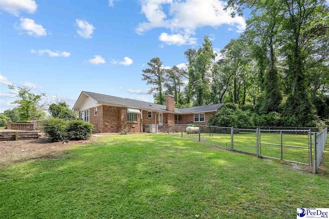3116 Kenfield Ln, Florence, SC 29505 - rear view of house with a gate, brick siding, and a chimney