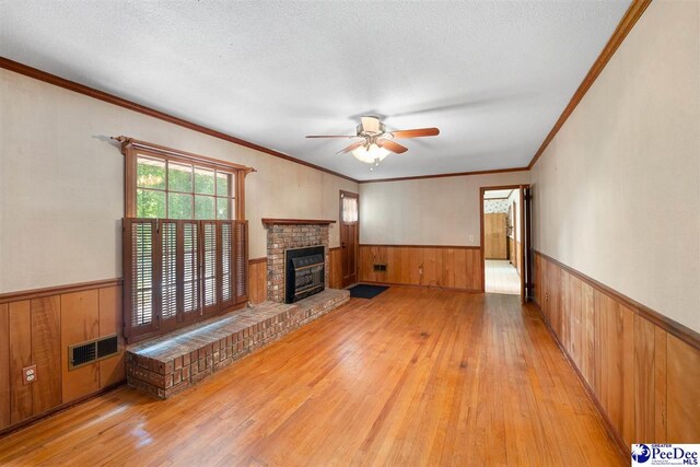 3116 Kenfield Ln, Florence, SC 29505 - unfurnished living room with a wainscoted wall, wood walls, hardwood / wood-style flooring, ceiling fan, and ornamental molding