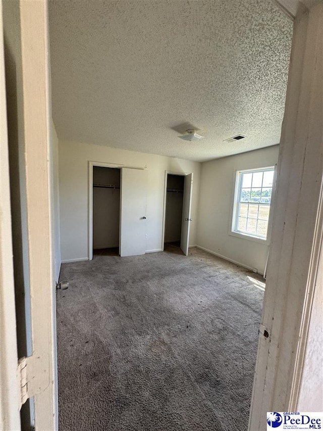 unfurnished bedroom featuring carpet and a textured ceiling