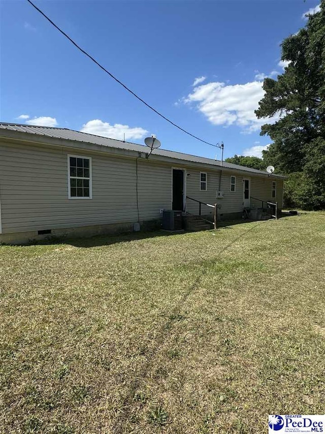 back of house featuring central AC and a yard