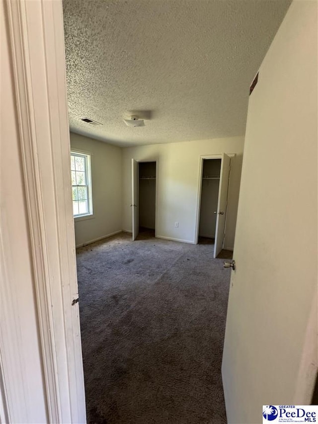 carpeted spare room with a textured ceiling