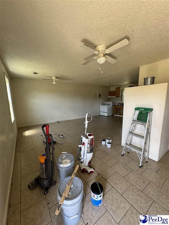 interior space with light tile patterned floors, a textured ceiling, and ceiling fan